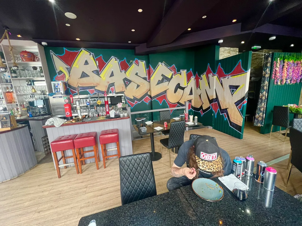 Gold graffiti mural across the walls of a café or restaurant interior