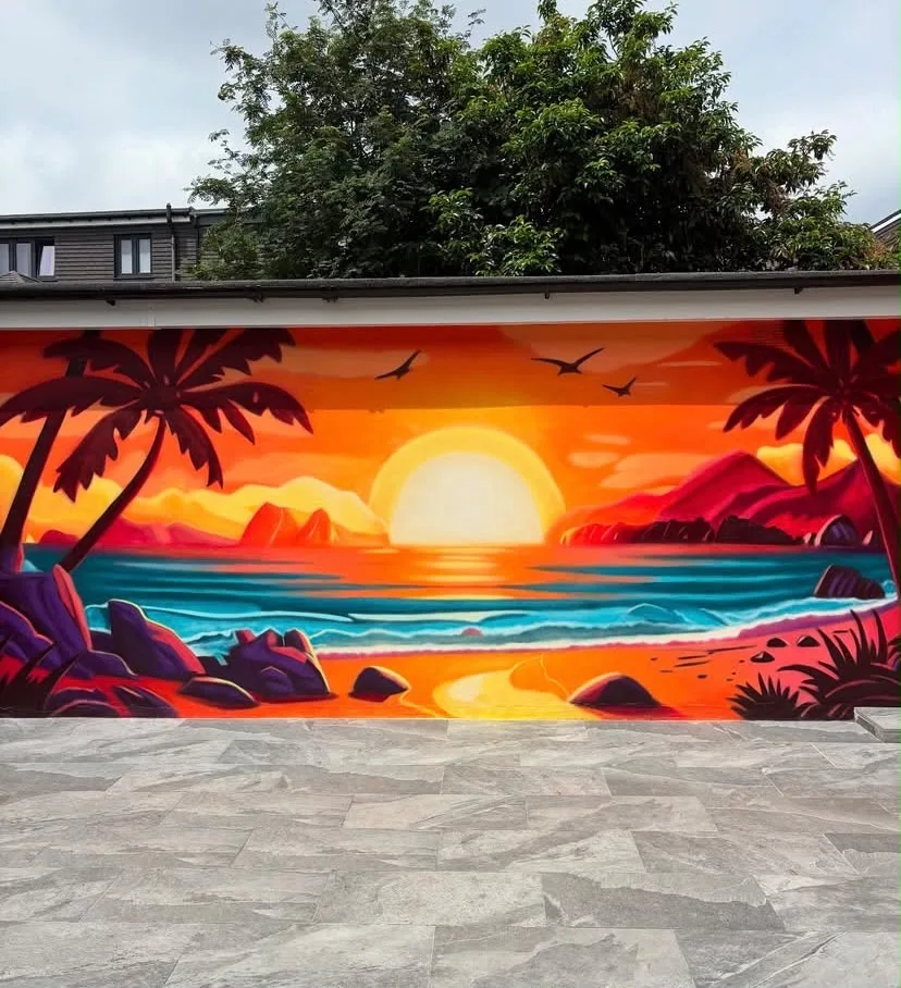 Bright tropical sunset and beach mural painted across an outdoor wall